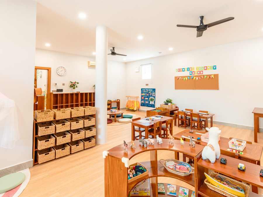Montessori practical life materials arranged in order on open wooden shelving