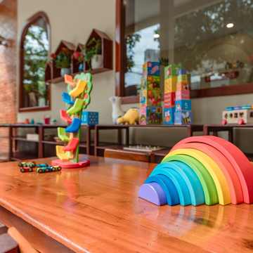 A wooden rainbow stacker set out on a classroom table